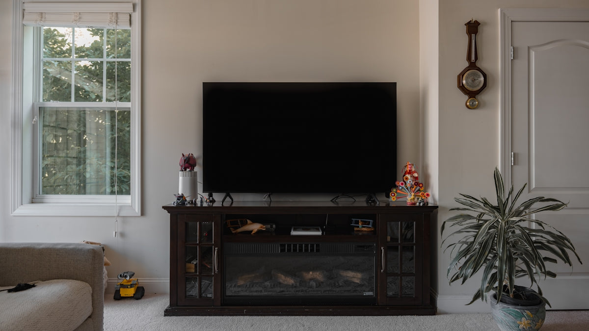a flat screen tv sitting on top of a wooden entertainment center